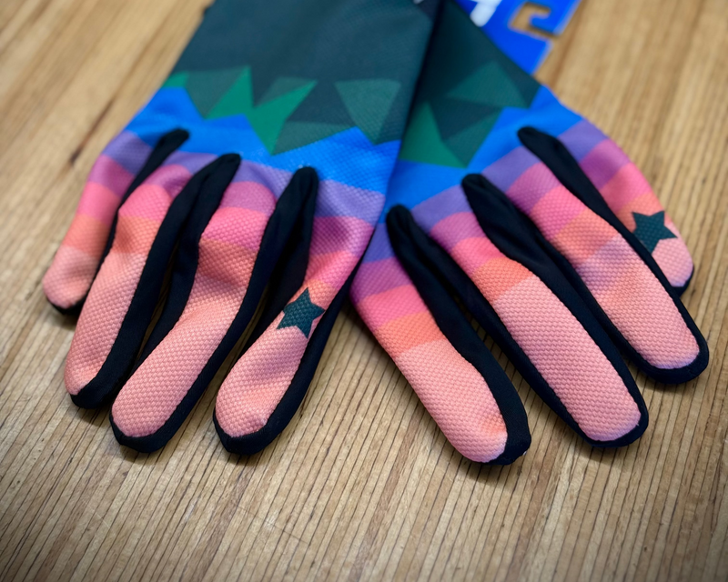 Colorful gloves with gradient design on a wooden surface
